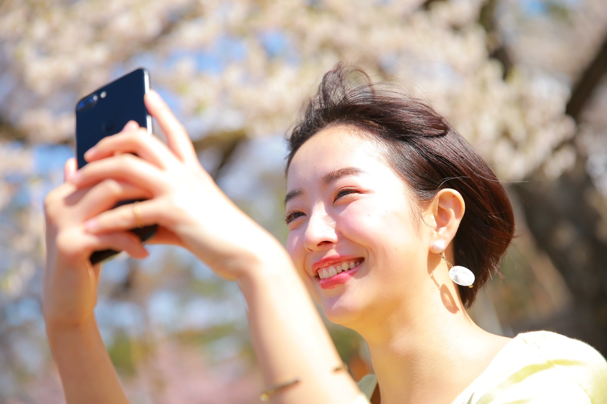 スマホで景色を撮影する女性