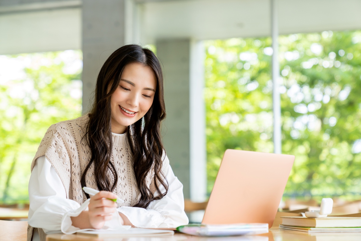 笑顔でノートパソコンを見る女性