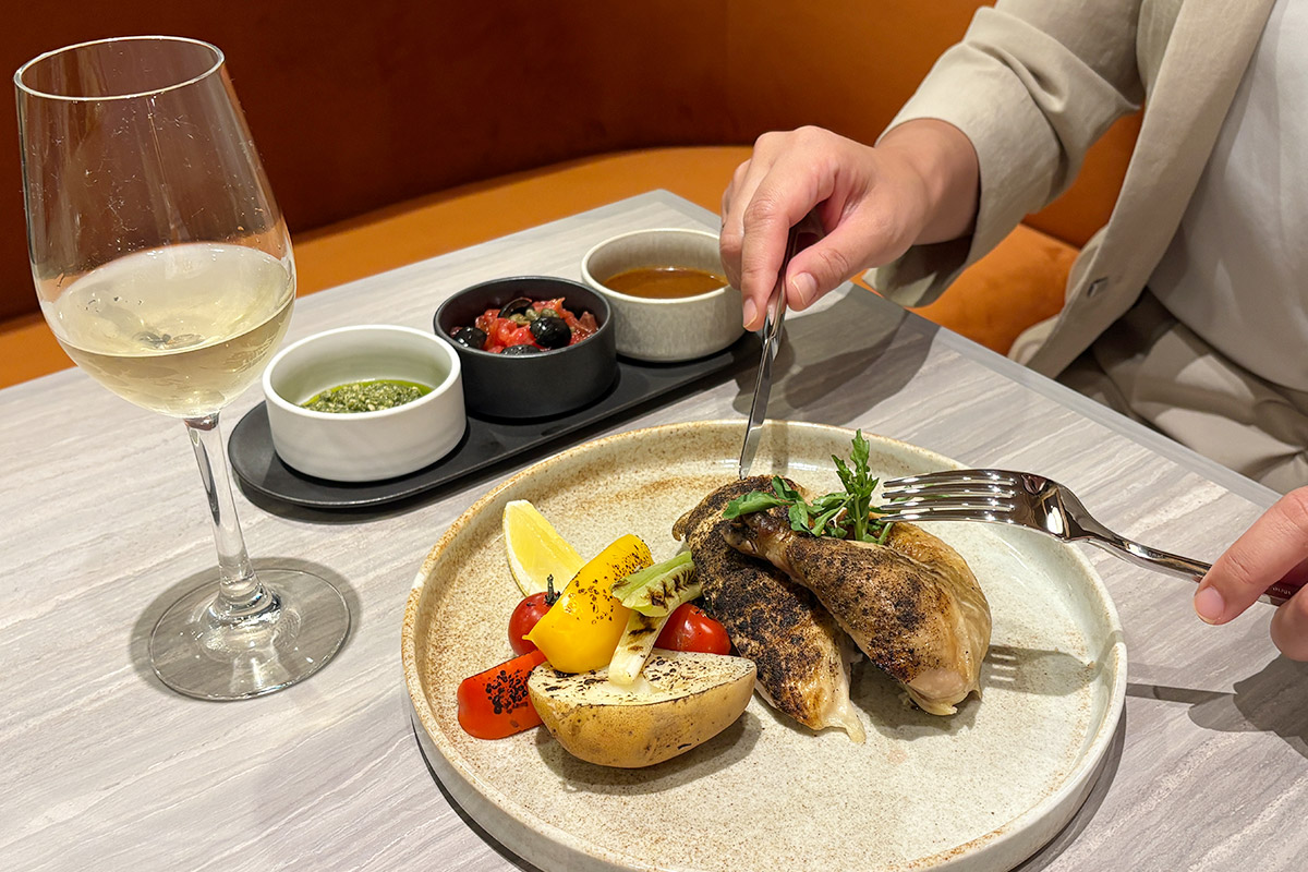 ロティサリーチキンを食べる女性とワイングラス